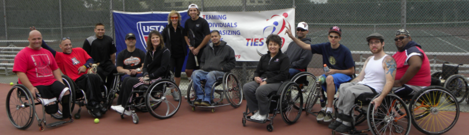 large group of ties tennis players and supporters in front of tennis courts with usta and ties banners behind them